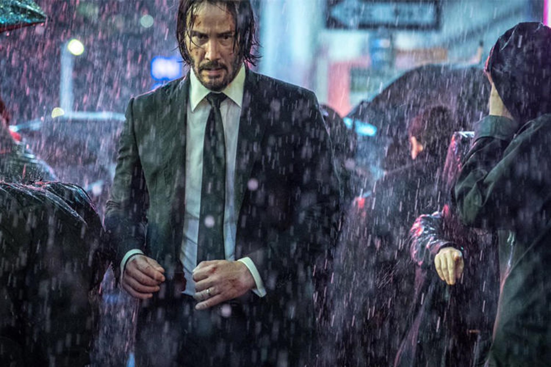 کیانو ریوز با کت و شلوار و کراوات زیر باران در فیلم John Wick 3: Parabellum