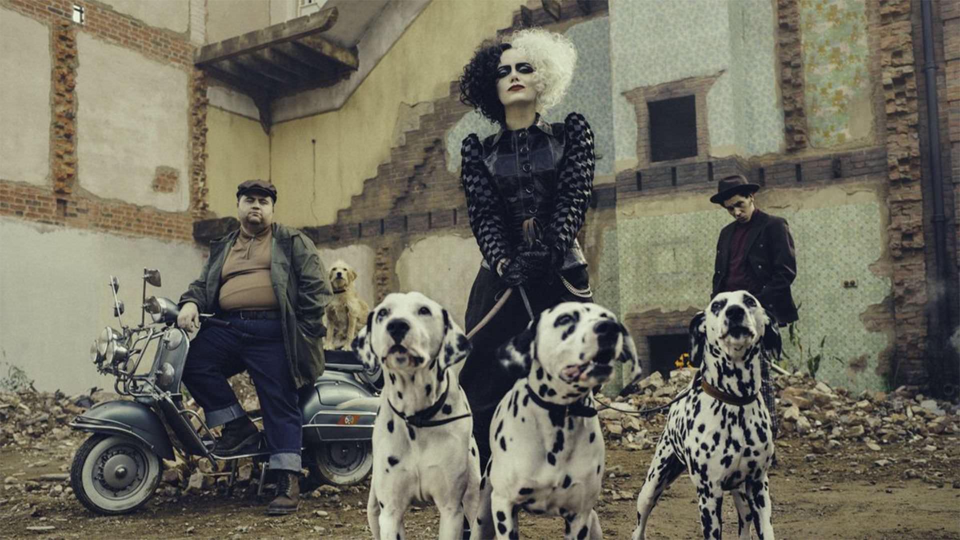 اما استون با ظاهر کامل شخصیت کروئلا دویل و سه سگ خالدار در فیلم Cruella