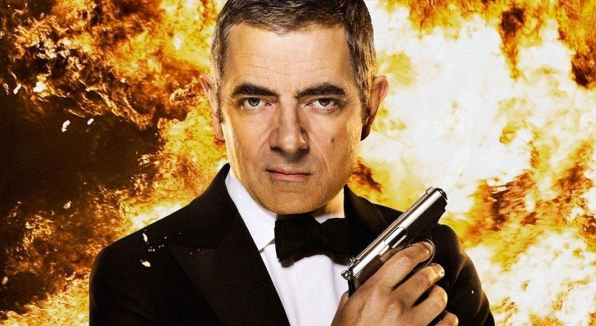 روآن اتکینسون در نقش یک جاسوس حرفه‌ای با بکگراند آتش در مجموعه سینمایی Johnny English 