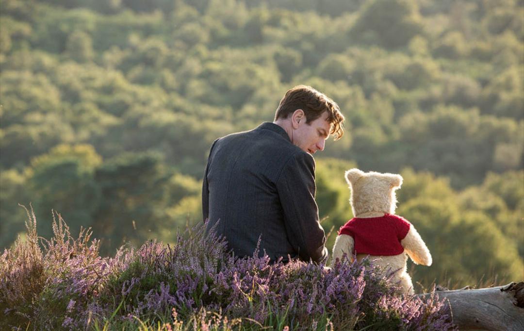 عکسی از نمای پشت سر شخصیت کریستوفر رابین به‌همراه دوست خرس خود در فیلم Christopher Robin 2018