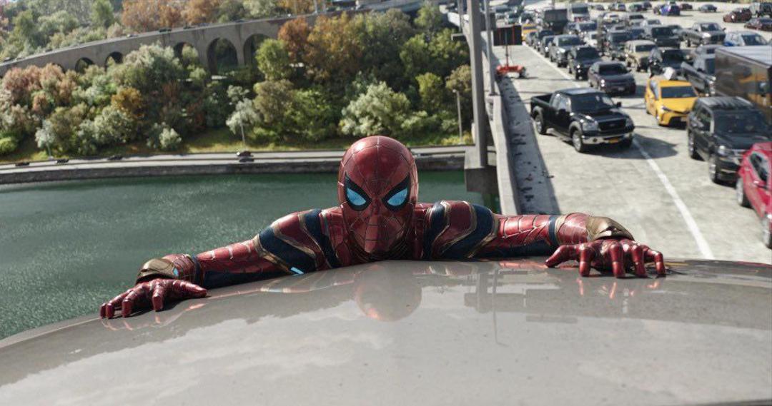 تام هالند در نقش مرد عنکبوتی چسبیده به ماشین در مبارزه با دکتر اختاپوس روی پل در فیلم Spider-Man: No Way Home
