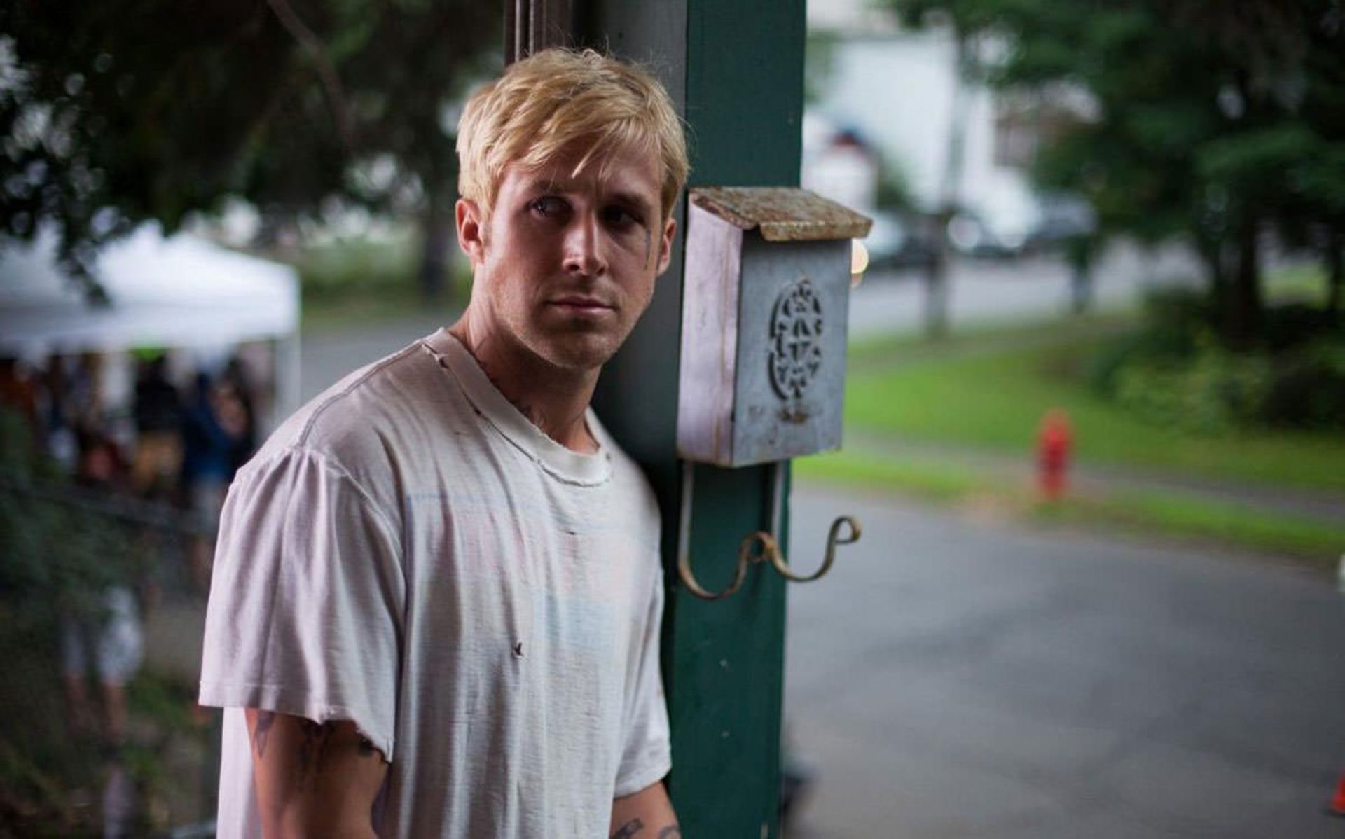 رایان گاسلینگ کنار با تی شرت سفید در خیابان فیلم The Place Beyond the Pines