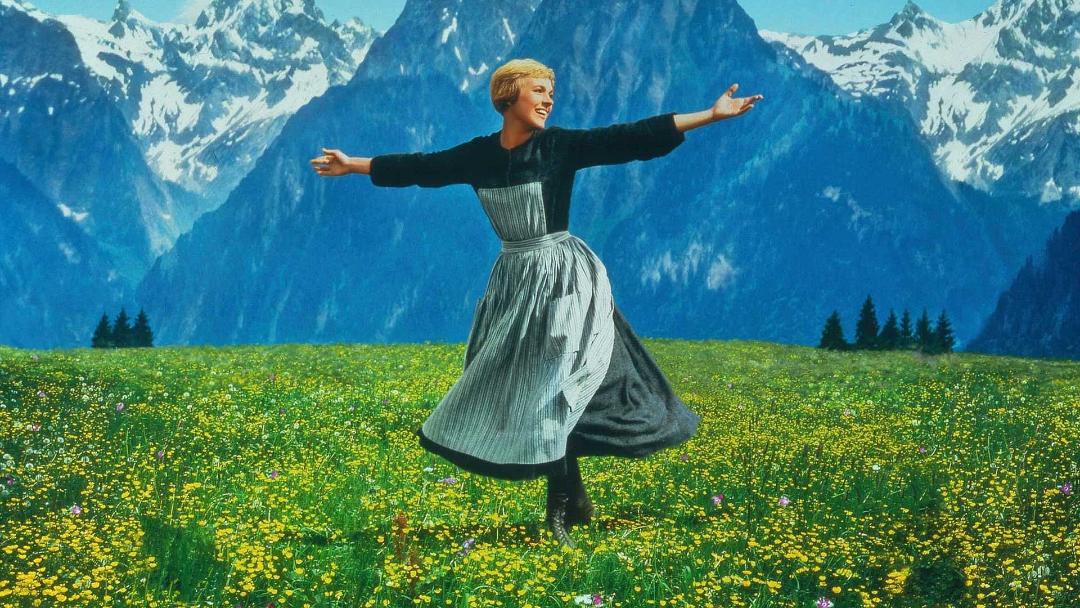 جولی اندروز با لباس بلند میان طبیعت در فیلم The Sound of Music دهه ۶۰ میلادی هالیوود