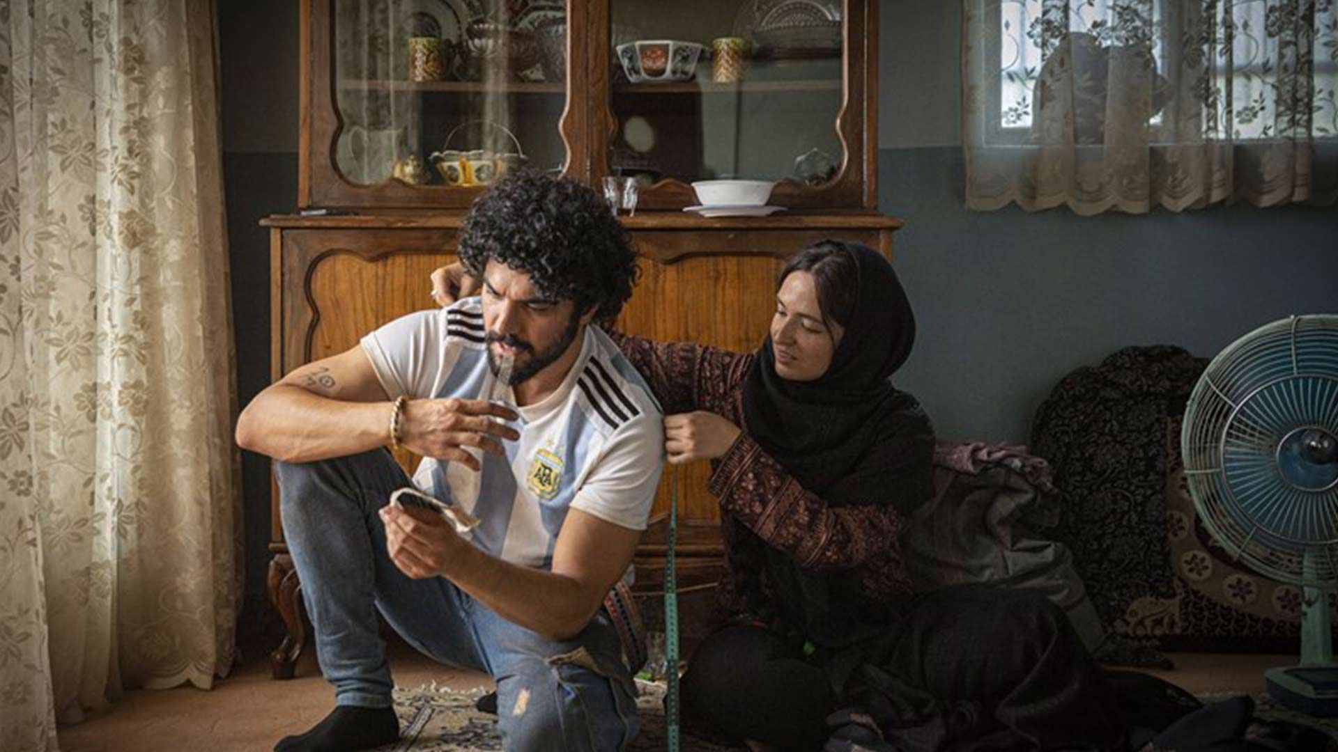 آهو در حال اندازه گرفتن لباس نادر در فیلم شادروان