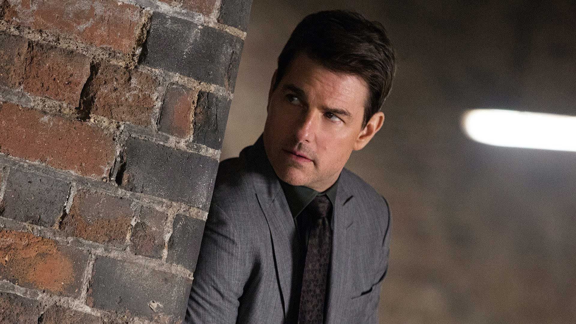 تام کروز در حال کاور گرفتن پشت دیوار و بررسی اوضاع در فیلم Mission: Impossible – Dead Reckoning Part One (ماموریت غیرممکن ۷)، یکی از مورد انتظارترین فیلم های سال ۲۰۲۳