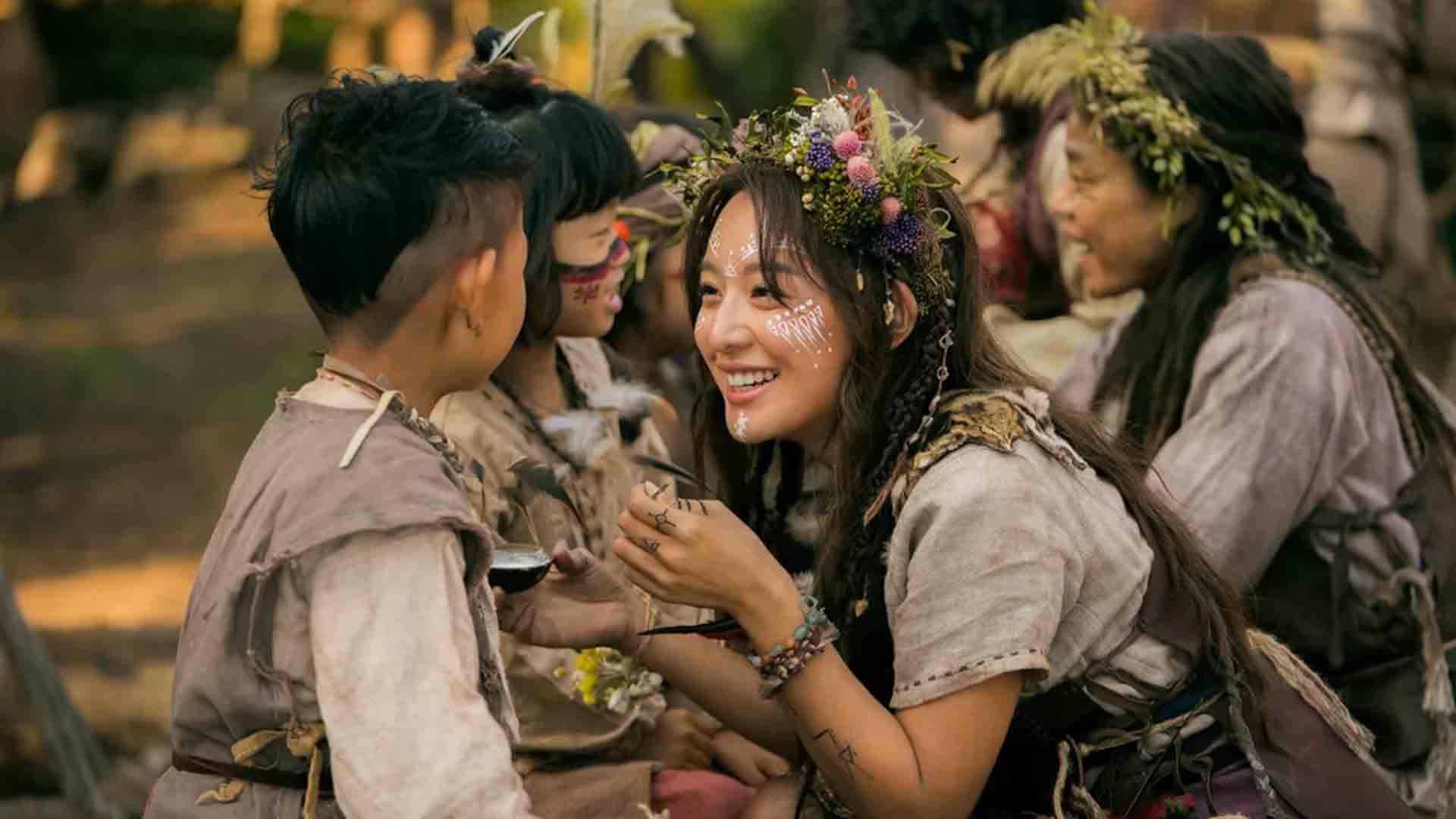 شخصیت تانیا در حال نقاشی کشیدن روی صورت بچه‌ها در سریال Arthdal Chronicles