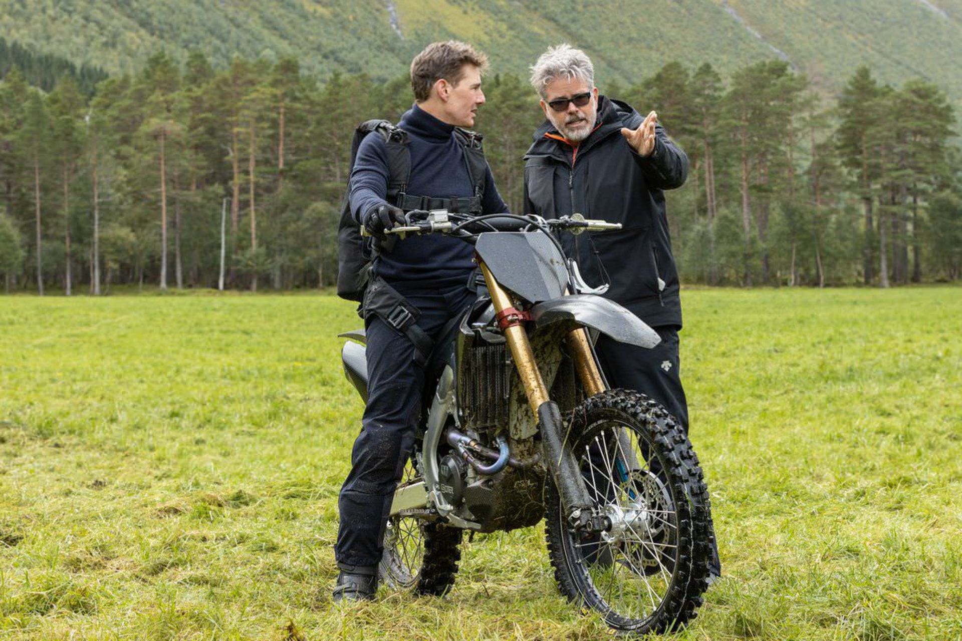 تام کروز سوار بر موتور درکنار کریستوفر مک‌کوری در پشت صحنه فیلم Mission: Impossible – Dead Reckoning Part One