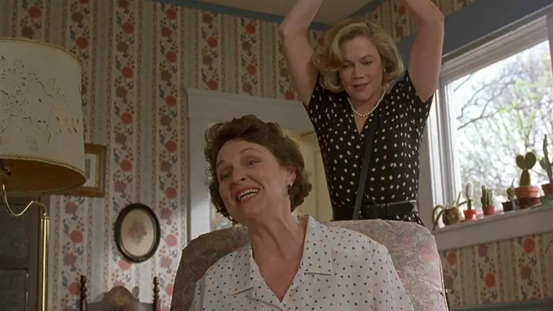 کتلین ترنر در حال کوبیدن یک جسم به سر همسایه در فیلم Serial Mom
