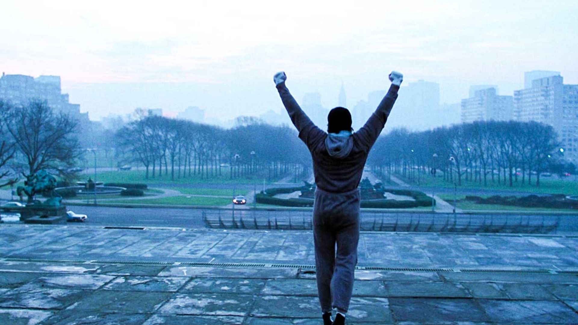 خوشحالی راکی با بازی سیلوستر استالونه بالای پله ها در فیلم Rocky، محصول سال ۱۹۷۶ میلادی