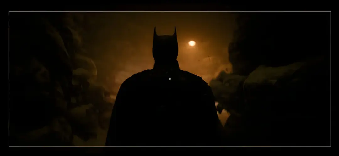 بتمن (Batman) در میان صخره‌ها و نورهای کم‌جان در فیلم بتمن ۲