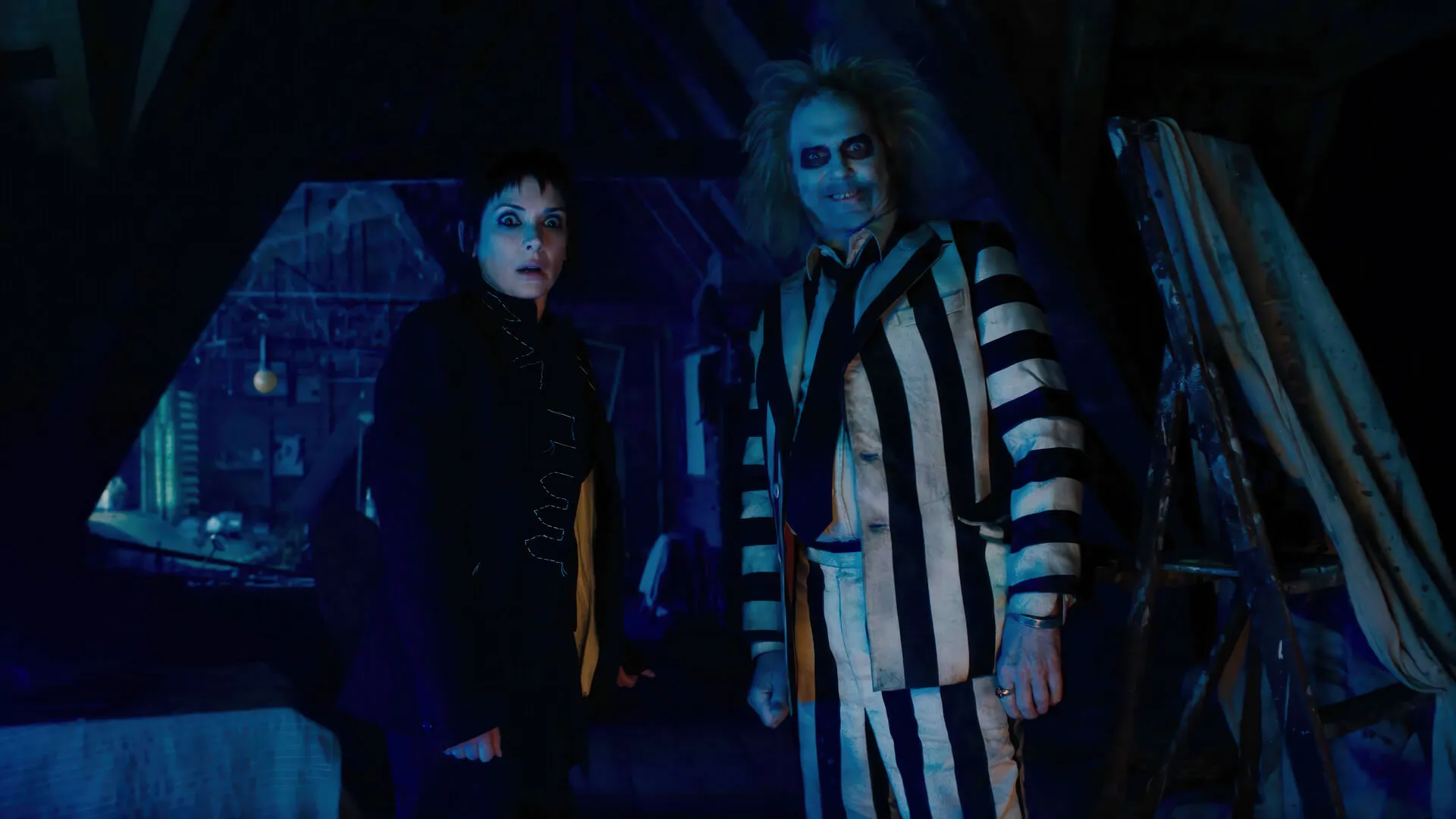 مایکل کیتون و وینونا رایدر در اتاق زیر شیروانی در فیلم Beetlejuice Beetlejuice