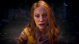 چهره نزدیک بازیگر نقش لافی در بازی God of War با موهای قرمز و لباس زرد