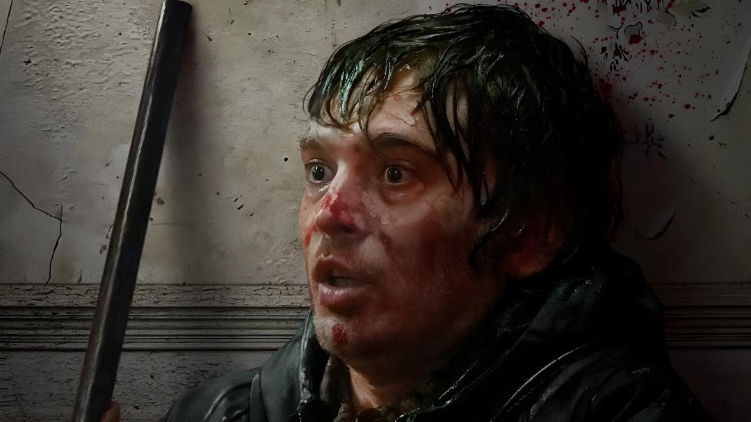چهره مردی زخمی و وحشت‌زده در فضای تاریک فیلم رزیدنت اویل (Resident Evil)