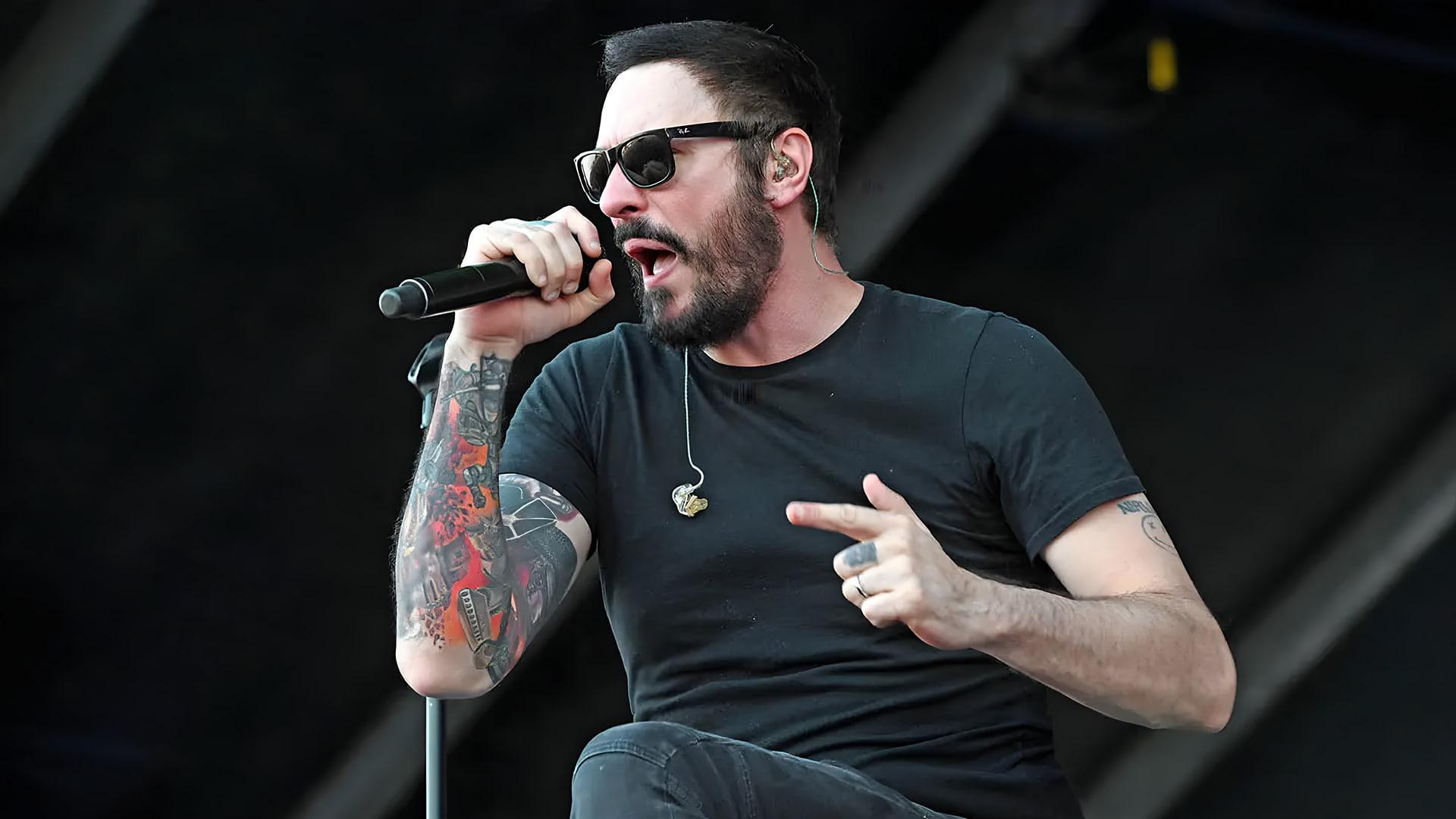 خواننده گروه بریکینگ بنجامین (Breaking Benjamin) در حال اجرای موسیقی با میکروفون