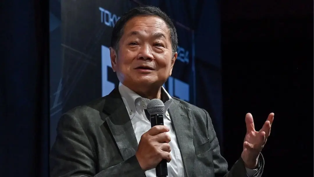 کن کوتاراگی (Ken Kutaragi) با میکروفون در حال سخنرانی در رویداد
