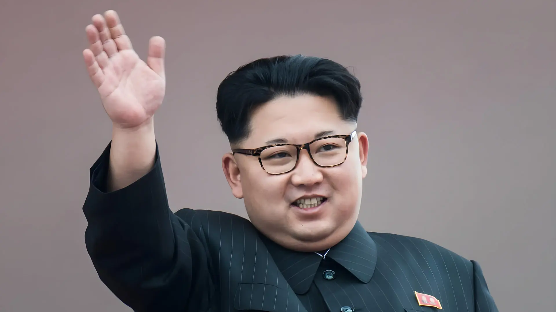 کیم جونگ اون (Kim Jong Un) رهبر کره شمالی با عینک و لباس رسمی در حال دست تکان دادن