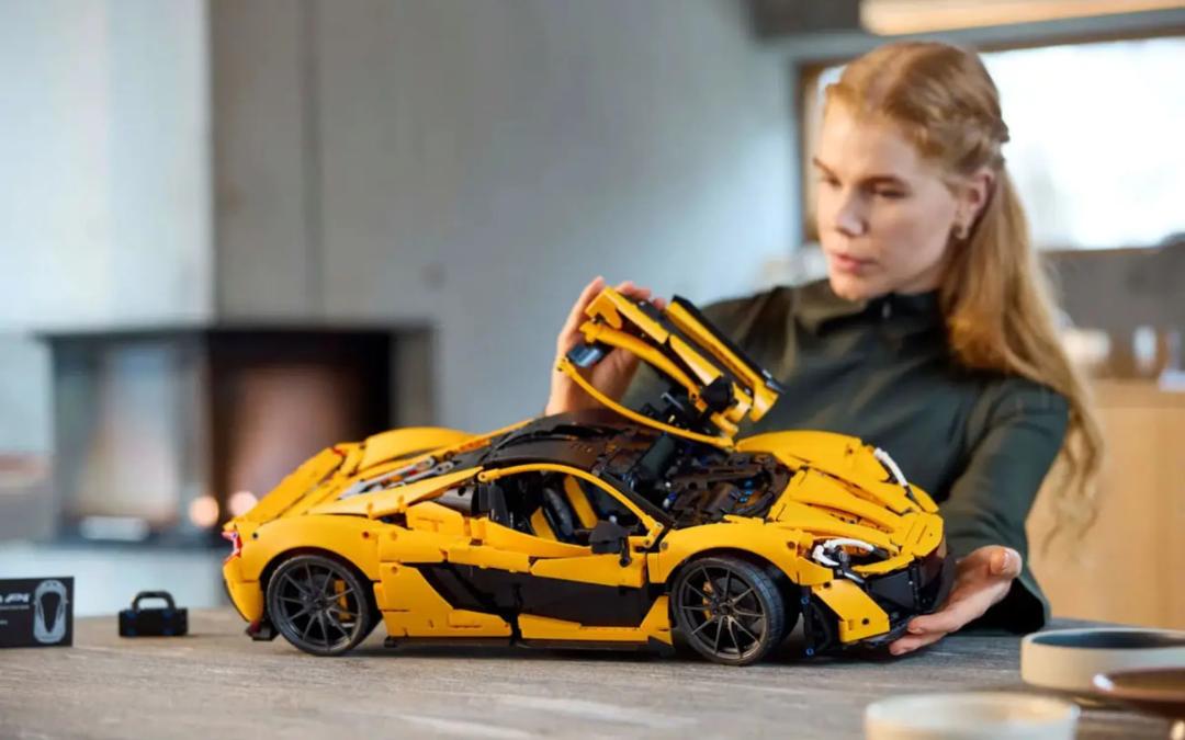 ماشین زرد لگو تکنیک (LEGO Technic) با درب‌های باز روی میز
