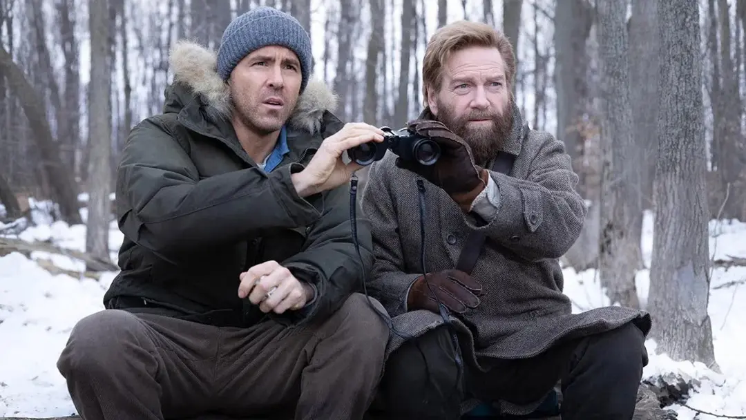 رایان رینولدز (Ryan Reynolds) و کنت برانا (Kenneth Branagh) با دوربین دوچشمی در جنگل برفی