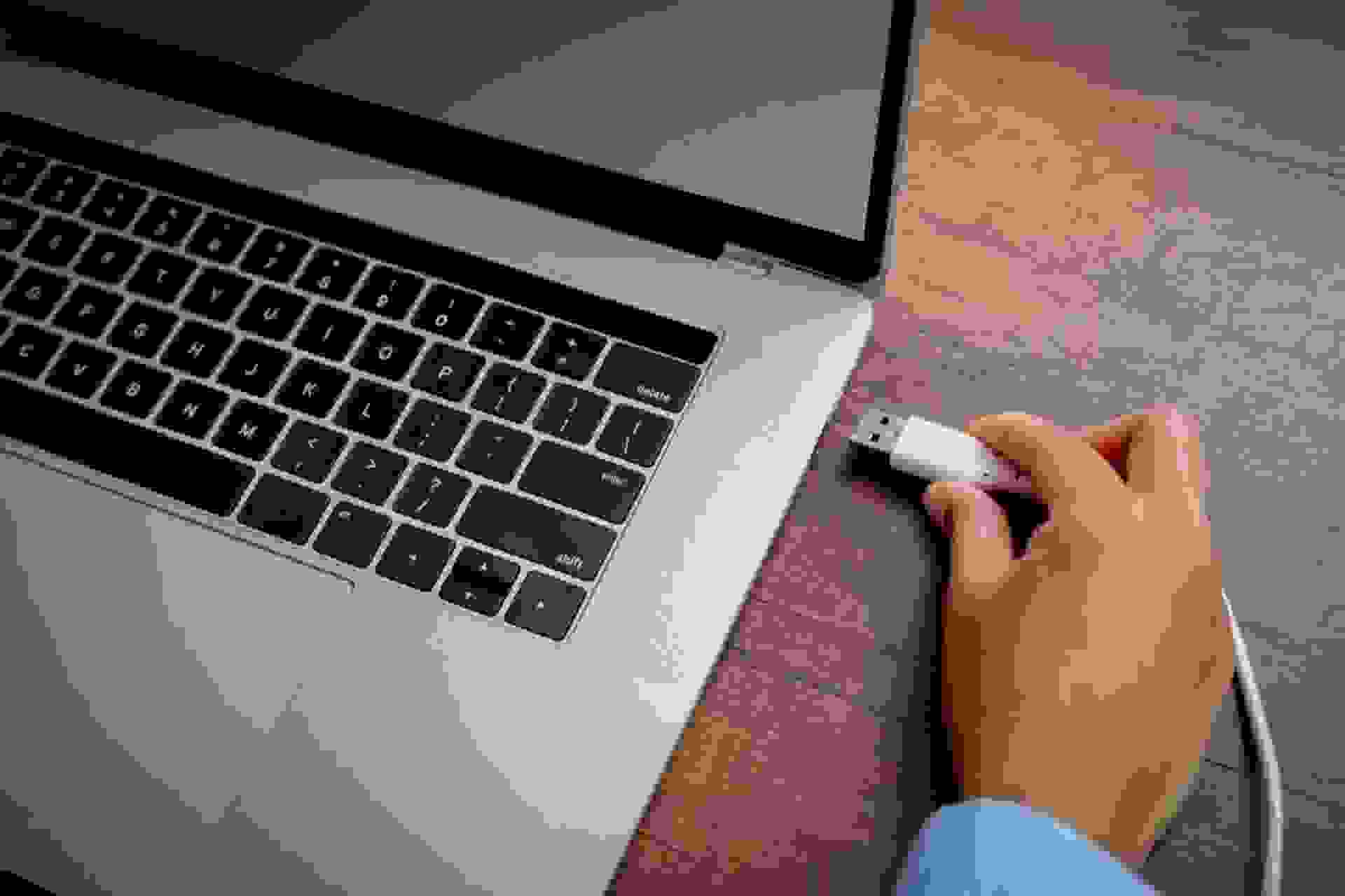 شخصی درحال وصل‌کردن کابل USB-A به لپ‌تاپ
