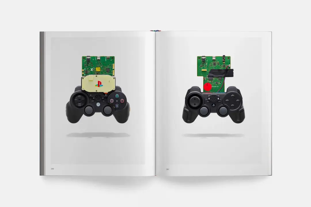 قطعات داخلی و برد الکترونیکی کنترلر پلی‌استیشن (PlayStation) روی صفحات کتاب