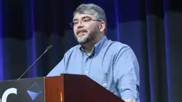 راف کاستر (Raph Koster) در حال سخنرانی پشت تریبون در کنفرانس GDC