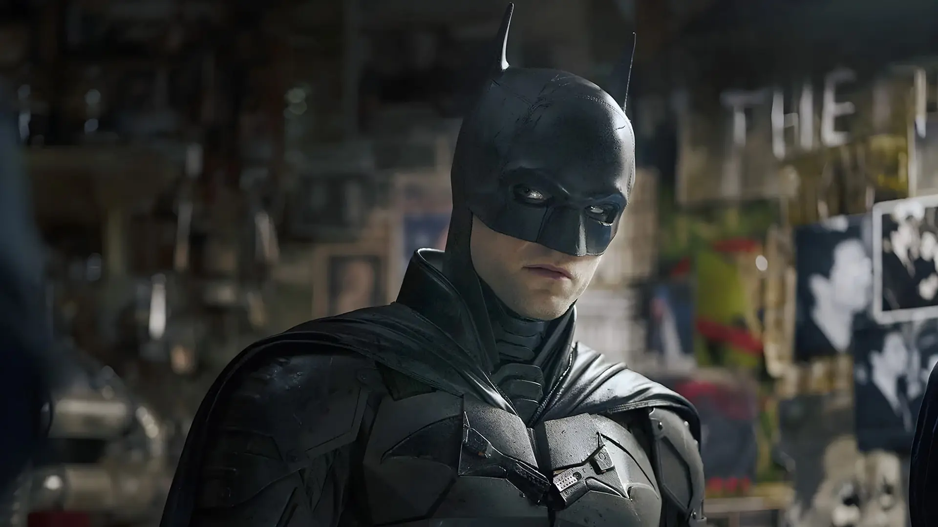 بتمن (Batman) با لباس زرهی سیاه در محیطی تاریک