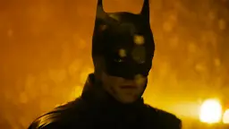 بتمن (Batman) با لباس سیاه در فضای بارانی و نورانی