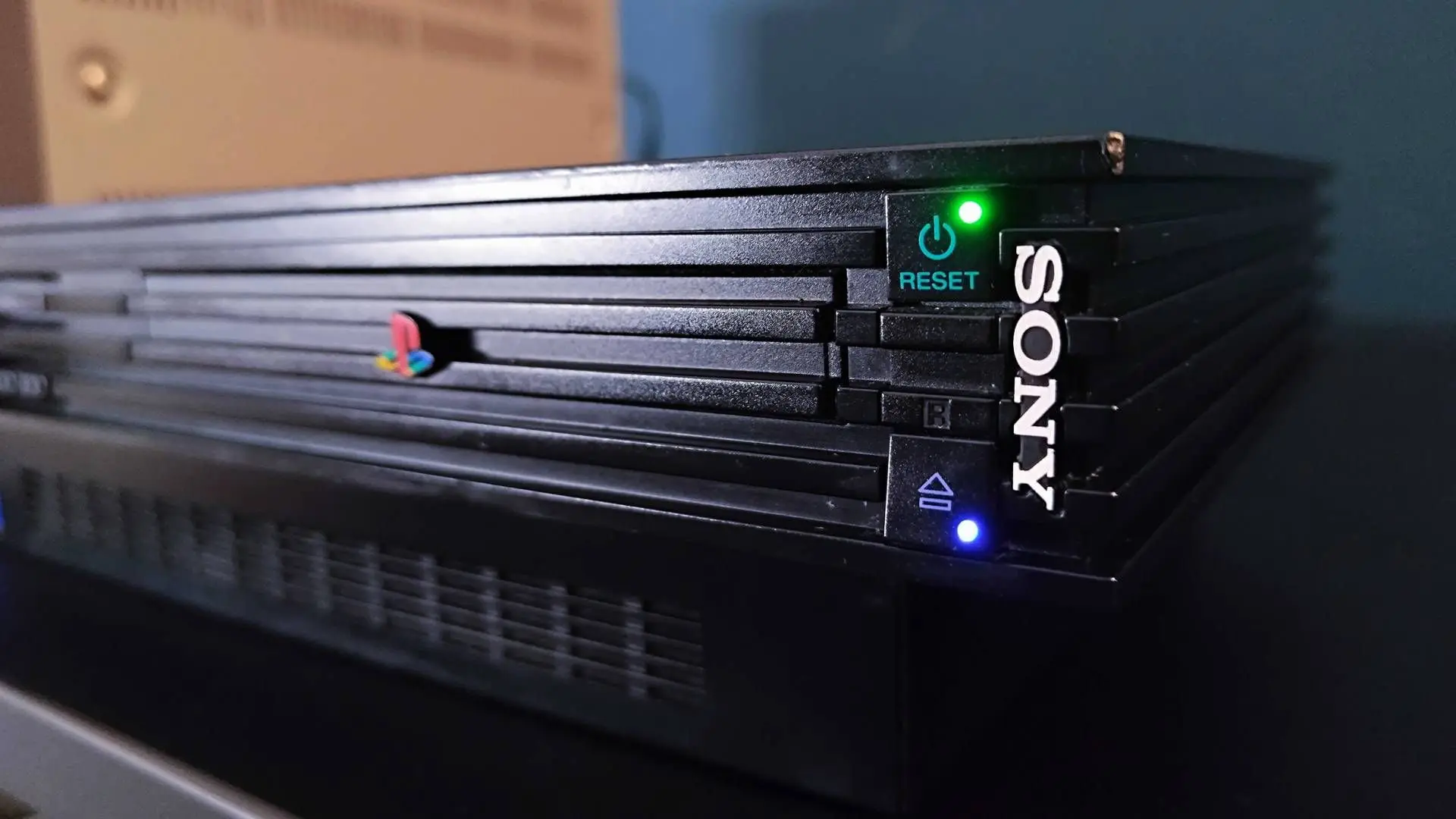 کنسول بازی پلی استیشن ۲ (PlayStation 2) با چراغ‌های روشن سبز و آبی