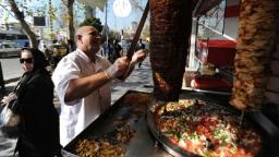آشپز در حال برش زدن کباب شاورما (Shawarma) در یک مغازه خیابانی