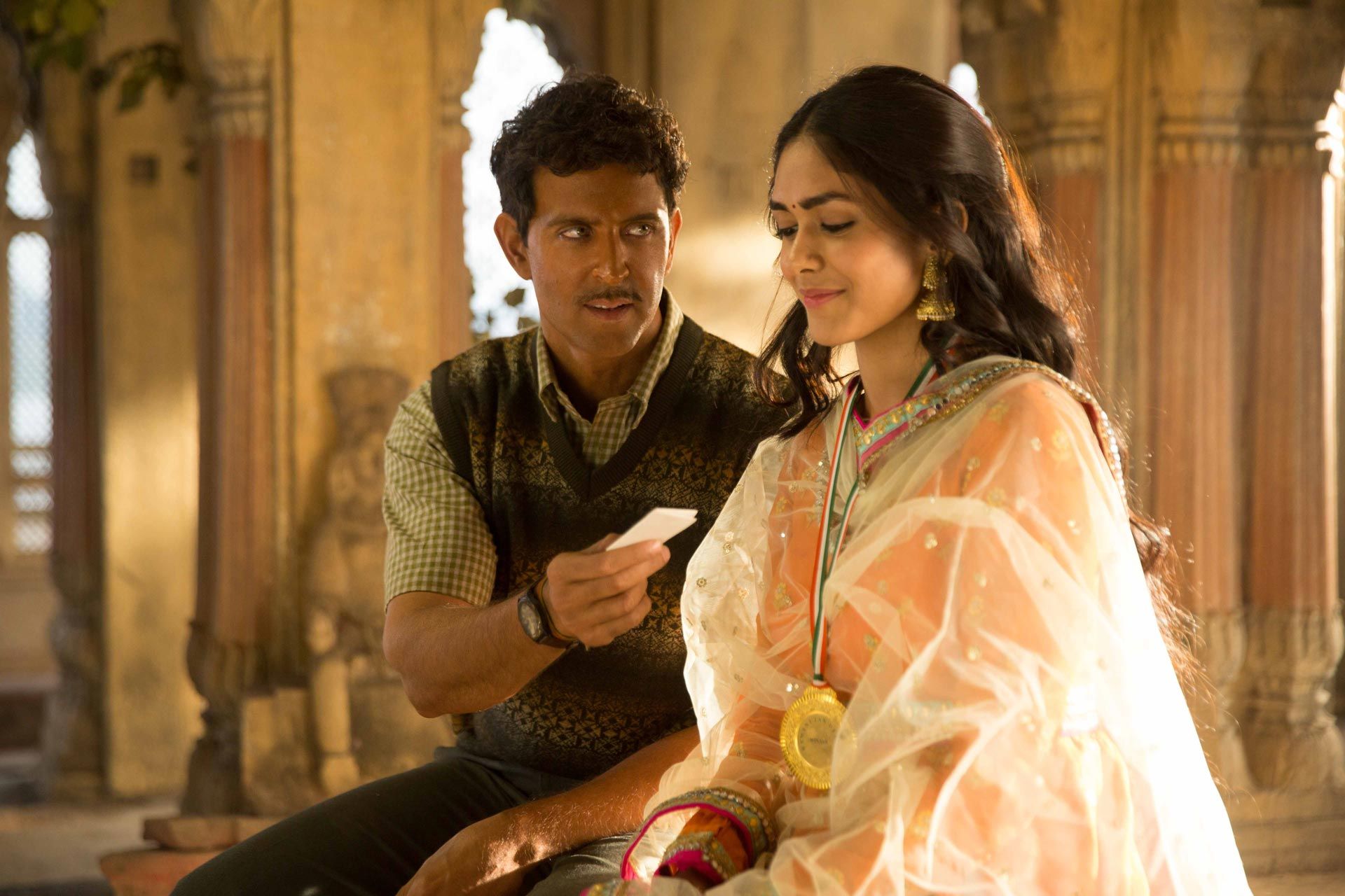 Super 30_hrithik_is_giving_a_piece_of_paper_to_a_woman