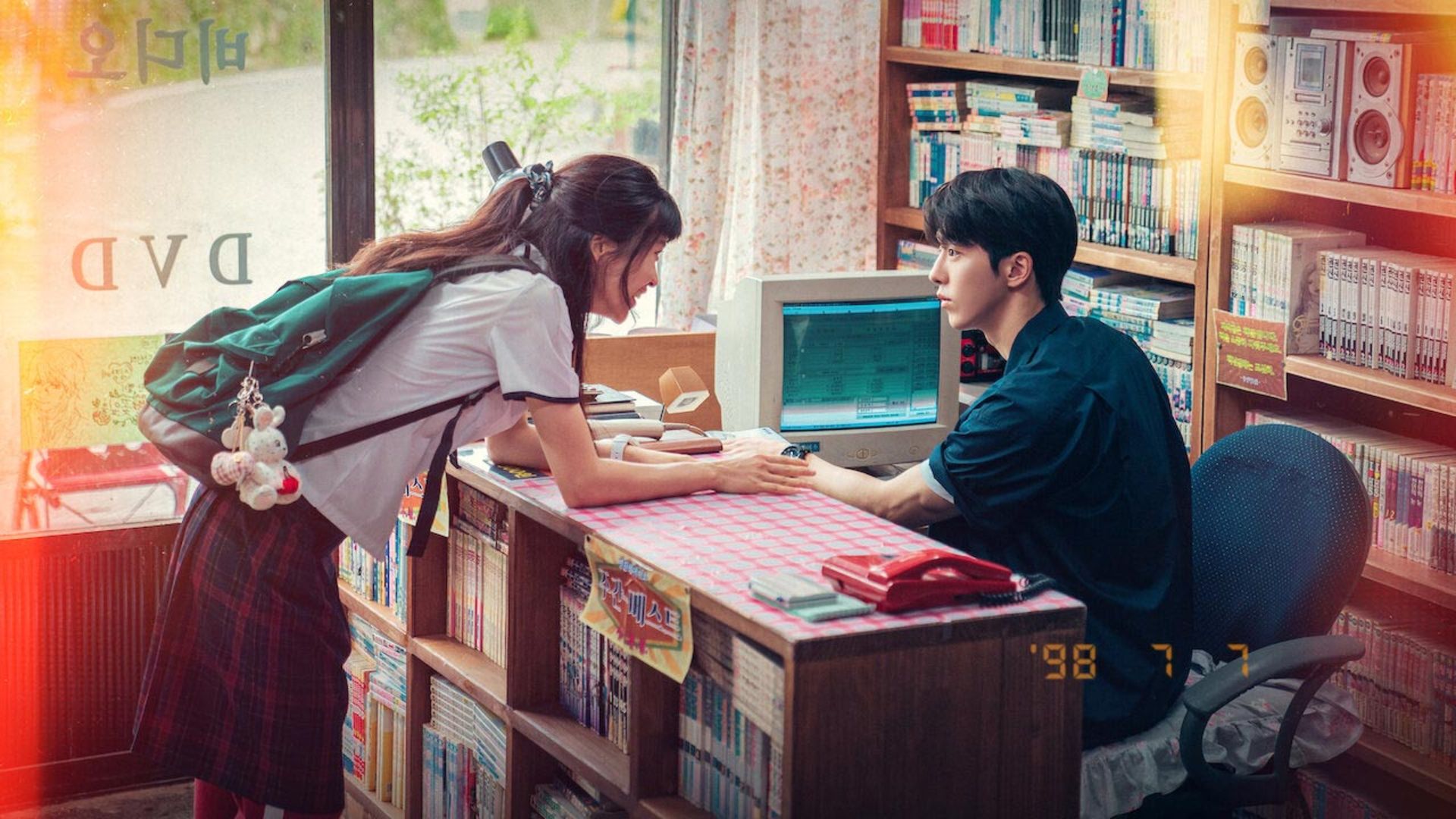 Twenty-Five_Twenty-One_boy_sit_behind_a_desk_look_at_a_smily_girl