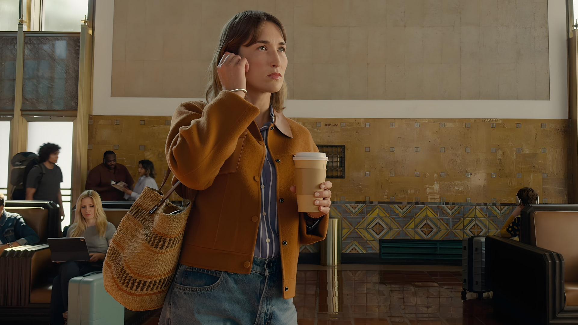 زن جوان در حال استفاده از ایرپاد (AirPods) در محیط ایستگاه یا فرودگاه