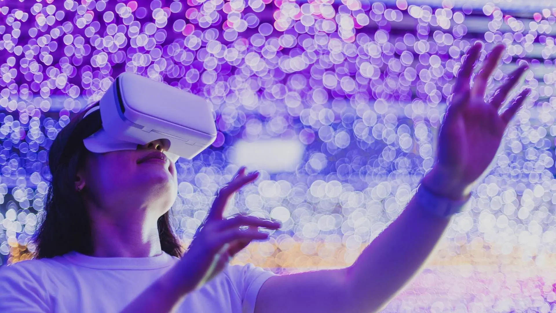 زن با هدست واقعیت مجازی (VR Headset) در محیطی با نورهای رنگی